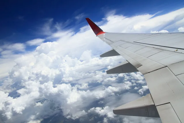 Vue depuis un avion en vol au-dessus des nuages avec aile et ciel bleu