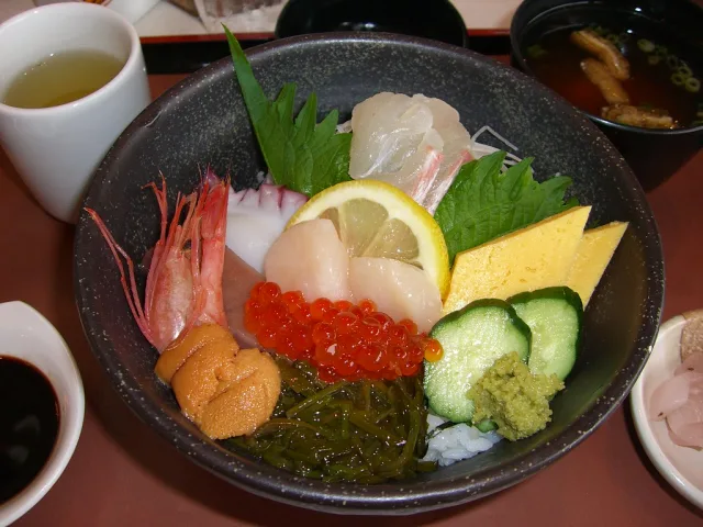Plateau de sashimi japonais traditionnel avec poisson blanc, œufs de saumon, crevettes et accompagnements
